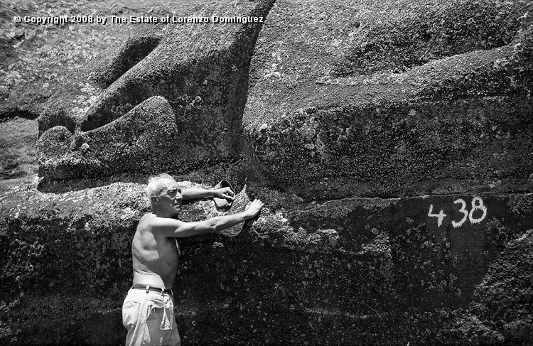 RRI_Cantera_Interior_09.jpg - Easter Island. 1960. Lorenzo DOminguez standing by one of the recumbent moai on the interior quarry of Rano Raraku.