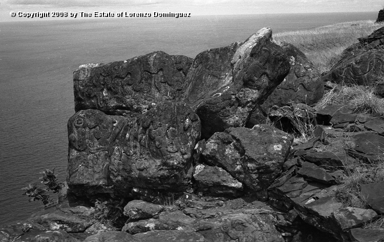 ORO_004.jpg - Easter Island. 1960. Orongo. Rocks on the cliffs with petroglyphs representing birdmen. To the right, the roof of a cave made out of stone slabs;